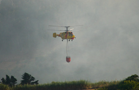 MACEIRA, PORTUGAL - AUGUST 14 : Fire rescue heavy helicopter with water bucket in summer fire in Maceira August 14, 2010 in Maceira, PORTUGALのeditorial素材