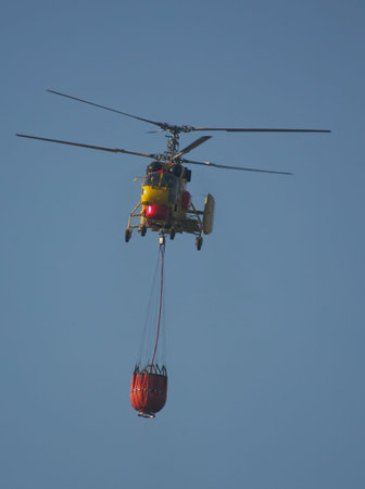 MACEIRA, PORTUGAL - AUGUST 14 : Fire rescue heavy helicopter with water bucket in summer fire in Maceira August 14, 2010 in Maceira, PORTUGALのeditorial素材