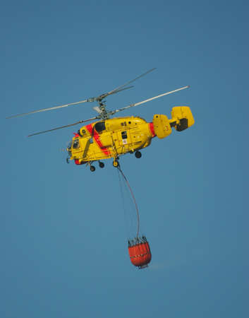 MACEIRA, PORTUGAL - AUGUST 14 : Fire rescue heavy helicopter with water bucket in summer fire in Maceira August 14, 2010 in Maceira, PORTUGALのeditorial素材