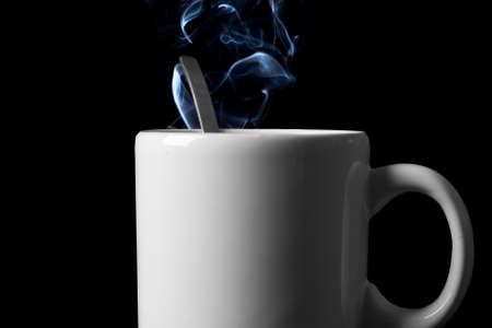 tea cup with vapor trail in black backgroundの写真素材