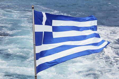 Greek Flag Fluttering With Sea Waves In Backgroundの写真素材