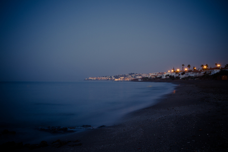 beach at night with city viewsの写真素材