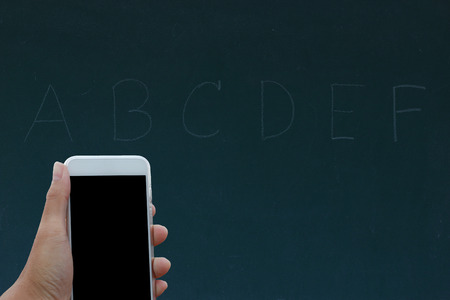 Hand holding phone black clipping inside on black boardの写真素材