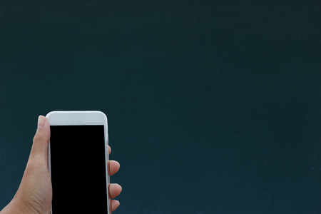 Hand holding phone black clipping inside on black boardの写真素材