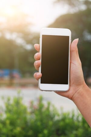 Hand holding phone isolated on black clipping insideの写真素材