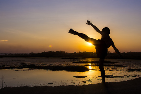Silhouette of the boys stand and to play with the sunset.の写真素材