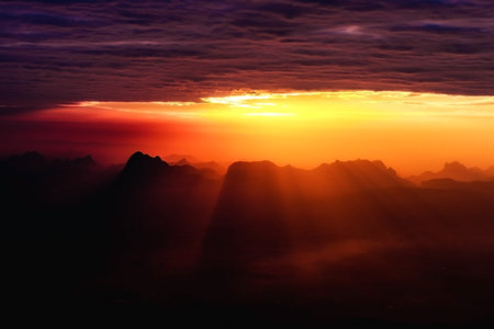 Sunset shines down on the mountainの写真素材