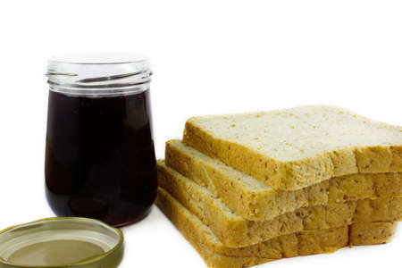Whole wheat bread stack with grape jam on isolated white background.の写真素材