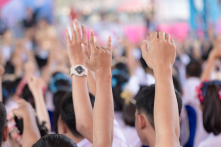 Student raising hands at high school.の写真素材