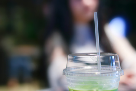 Iced matcha green tea latte on table with women working in store.の写真素材