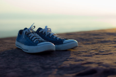 Shoes on rocks with cliffs, blue sky and sea as a background Represents the conceptualの写真素材