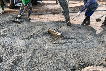 Workers pouring reinforced concrete floors on siteの写真素材
