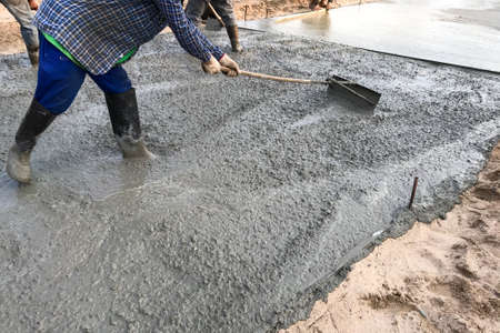 Workers pouring reinforced concrete floors on siteの写真素材