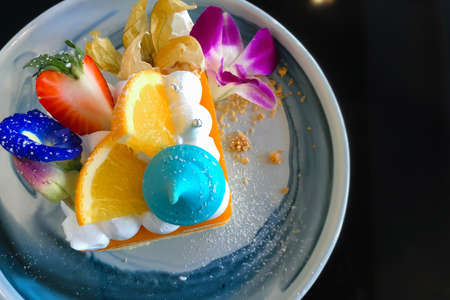 Orange cake with orange topping on plate ready to eatの写真素材
