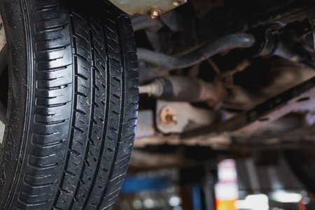 The mechanic is checking the undercarriage of the car.の写真素材