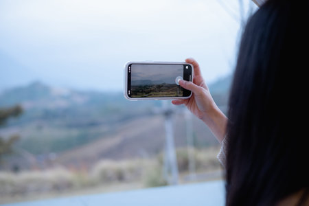 Woman is checking Bitcoin price chart on digital exchange on smartphone, cryptocurrency future price...