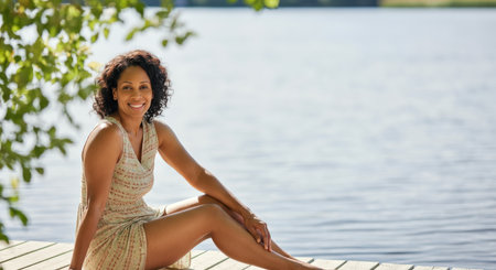 Serene summer day by the lake with smiling african american woman in elegant dressの素材