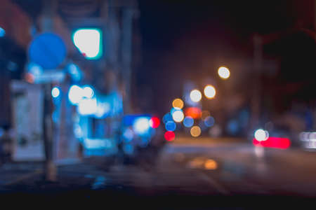 defocused night city life, cars, cyclist and street lampsの写真素材