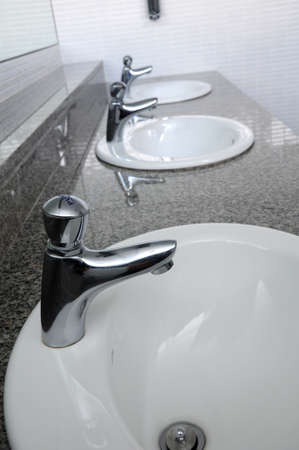 Row of faucets in  toilet at my officeの写真素材