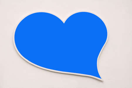 Blue heart shape on white wall backgroundの写真素材