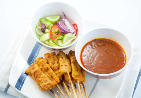 Grilled pork satay, peanut sauce and vinegar on white backgroundの写真素材