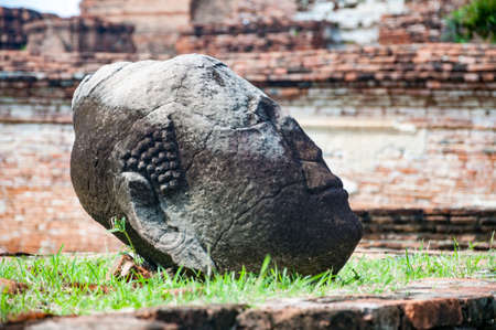 Old head of Buddha destroyed at Wat Mahathat (Temple of the Great Relics), Ayutthaya, Thailand. This temple is public place. Public temple in Thailand.の写真素材