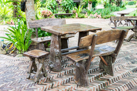 Wooden table and chairs in the gardenの写真素材
