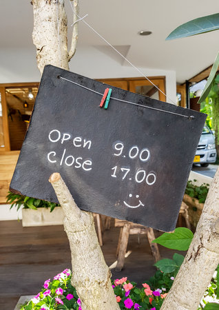 Wooden sign and time to opening and closing stores.