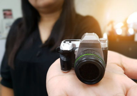 Woman holding camera toy in her handの写真素材