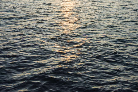 Close up sea wave surface with sunrise in the morning backgroundの写真素材