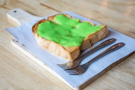 Pandan custard bread on wooden dish for break time.の写真素材