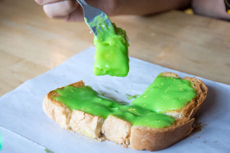 Pandan custard bread on wooden dish for break time.の写真素材
