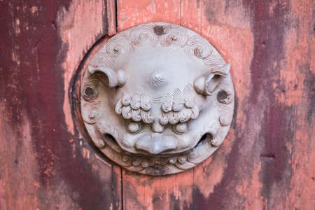 An old wooden red door at the entrance of a Nagasaki templeの写真素材