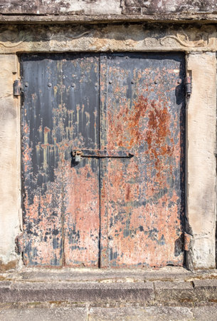 rusty metal door on a plaster wallの写真素材