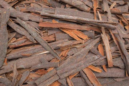 A collection of cinnamon sticks and bark pieces sold in a marketの写真素材