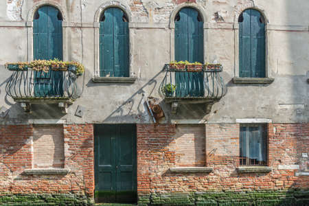 An old Venician house with five window and a doorの写真素材