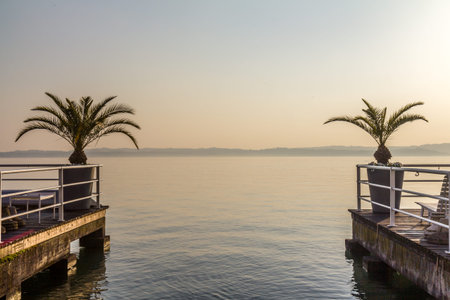 A sunset over lago de garde town, view from the pierの写真素材