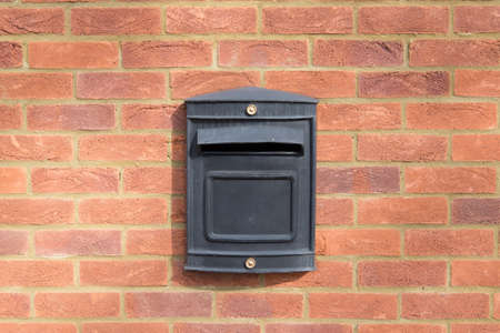 black metal letter box on red brick wallの写真素材
