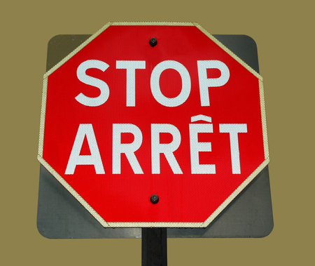 bilingual stop sign on creme background
