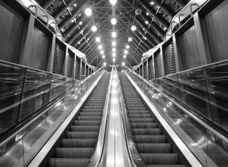 Glass lifts up the escalator to switch lights illuminated at nightの写真素材