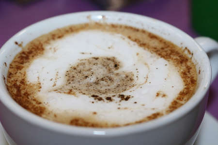 Freshly brewed cappuccino, with a decorative pattern on the foam heartの写真素材