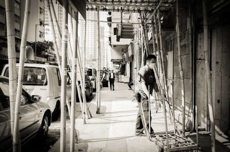 On December 4, 2017, construction workers under the scaffolding of street architecture in Hong Kong were pushing trolleys to work.のeditorial素材