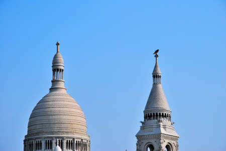 White, European style church architecture with bird perched on roofの写真素材