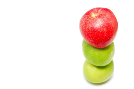 A group of apples with a single red apple standing out from the crowdの写真素材