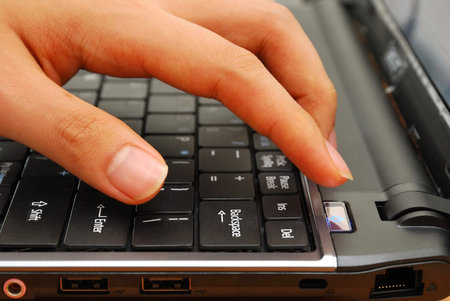 Finger pressing power button on laptop kepboard. For concepts such as electronics and technology,...