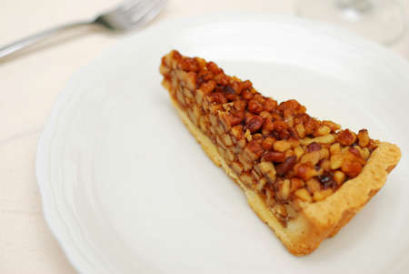 A single slice of hazel nut tart on white plate. For concepts such as food and beverage, diet and nutrition, and healthy eating.の写真素材