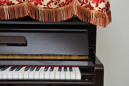 Blac red upright piano with open view of keyboard, light from left. Signifying concepts such as music and creativity, and musical objects.の写真素材
