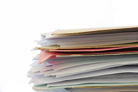 Stack of files full of documents signifying concepts such as work and stress, and work life and...