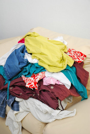 Messy and unfolded clothes on sofa isolated on white background. For lifestyle concepts.の写真素材