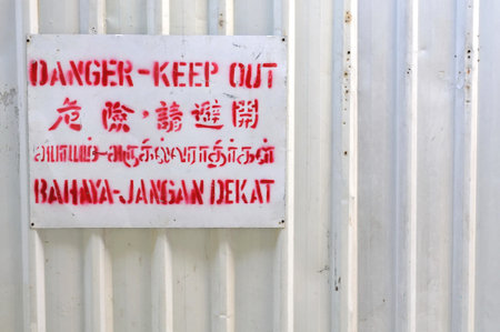 Danger signboard on white fence. For safety and danger, signs and symbols concepts.